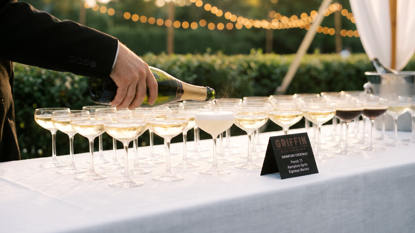 Champagne poured into coupes at the bar