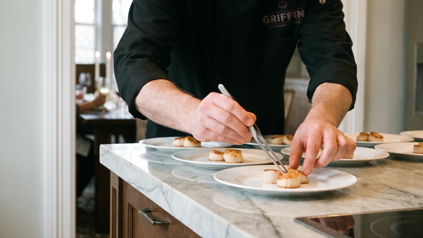 A Griffin chef plating seared scallops in a home kitchen